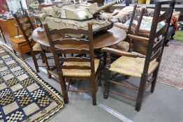 An antique oak gateleg table having one drawer and set of 5 ladder back chairs, including one with o