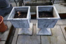 A pair of modern lead style square planters on shaped base