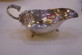 Edwardian silver sauce boat with scalloped design rim and three paw feet. Hallmarked Chester 1905 Wi