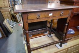 An antique oak side table having one drawer on turned legs