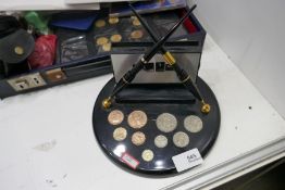 Quantity of coins in case and a pen holder inset coins