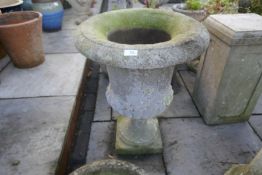 A reconstituted garden urn on associated pillar