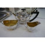 A silver tea service comprising a George V tea pot and a silver gilt sugar bowl and milk jug. With h
