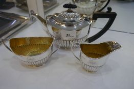 A silver tea service comprising a George V tea pot and a silver gilt sugar bowl and milk jug. With h