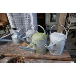 Collection of galvanised watering cans and bucket