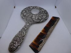 A pretty and ornate silver dressing table set consisting of a silver backed hand mirror, two brushes