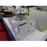 A very heavy glass inkwell with a cut glass base and a silver top, hallmarked London 1901 Goldsmiths