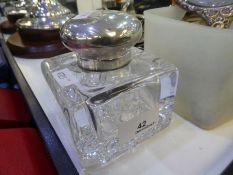 A very heavy glass inkwell with a cut glass base and a silver top, hallmarked London 1901 Goldsmiths