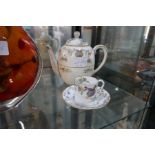A Royal Worcester teapot and matching cup and saucer
