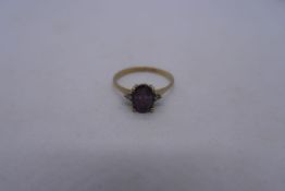 9ct yellow gold ring with a  central oval amethyst flanked two diamond chips, marked 375, size P, 1.