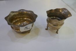 A silver creamer and silver sugar bowl with flare design rim on three feet, AF. Hallmarked Birmingha