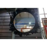 A circular wall mirror frame with decorated figures