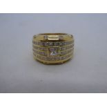 18ct yellow gold thick gold band ring with central approx 0.5 carat diamond within four rows, channe