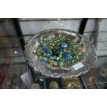 A quantity of marbles in silver plated dish