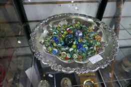 A quantity of marbles in silver plated dish