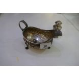 A silver Victorian half reeded decorative sauce boat on three decorative feet with a foliate handle