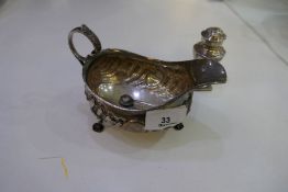 A silver Victorian half reeded decorative sauce boat on three decorative feet with a foliate handle