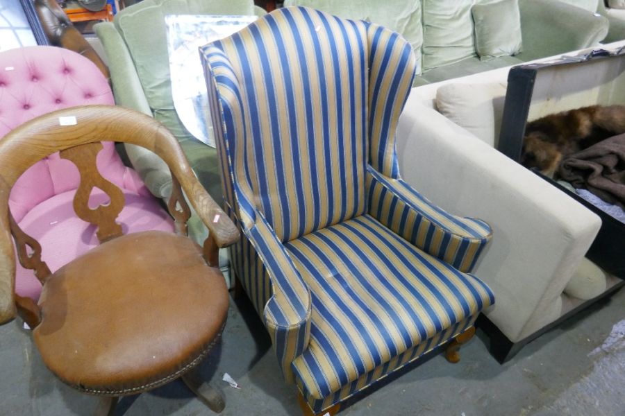 A wing armchair having stripped upholstery and a button back tub chair
