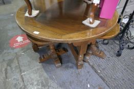 An oak circular coffee table with 4 smaller tables