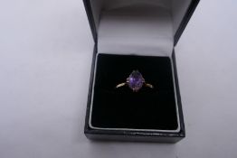 Unmarked yellow metal dress ring set with a single oval amethyst stone, size N, unmarked. 1.9g