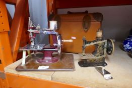 Two vintage hand cranked sewing machines, patent no 266 759, on one of the sewing machines