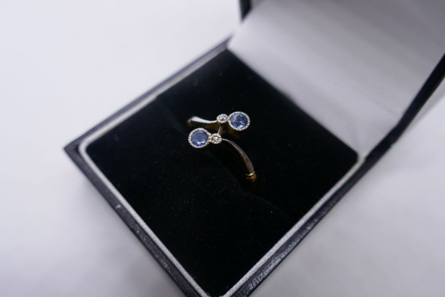 18ct two tone crossover design ring inset with two pale blue sapphires and two small diamonds, marke - Image 4 of 4