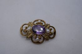 9ct gold floral design brooch with central oval faceted amethyst surrounded by 6 seed pearls, marked