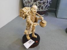 A 19th century Japanese Ivory figure of fisherman holding crab, on signed wooden base, 14cm