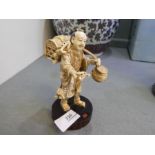 A 19th century Japanese Ivory figure of fisherman holding crab, on signed wooden base, 14cm