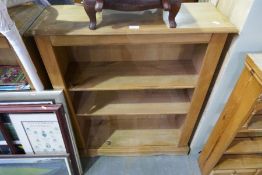 A pair of modern Ikea bookcases and a white cane armchair