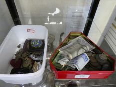 A small tub of military badges and a tub containing mixed coinage and notes