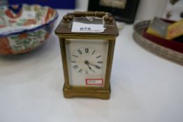 A vintage carriage clock with a French movement, damage to enamel face