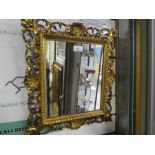 An antique carved Florentine wall mirror having pierced border