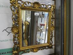 An antique carved Florentine wall mirror having pierced border