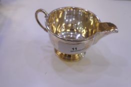 A matching silver sugar bowl and a creamer on a raised pedestal foot and foliate handles. Nice shape