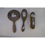 A silver backed dressing table set of similar design comprising a hand mirror, and two brushes with