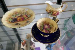 An Aynsley plate, jug and cup and saucer decorated with fruit