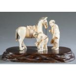 Ivory okimono of two men and a horse