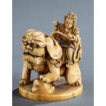 Ivory netsuke of god riding a Foo dog, 19th c.