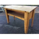 A large pine clerks desk with sloping work surface above an open compartment, raised on tapering