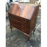 An Edwardian mahogany bureau, the fallfront with carved ribbed corners enclosing a fitted interior