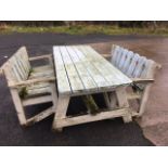 A six foot garden table and two matching benches, the table with six plank top and seats with shaped