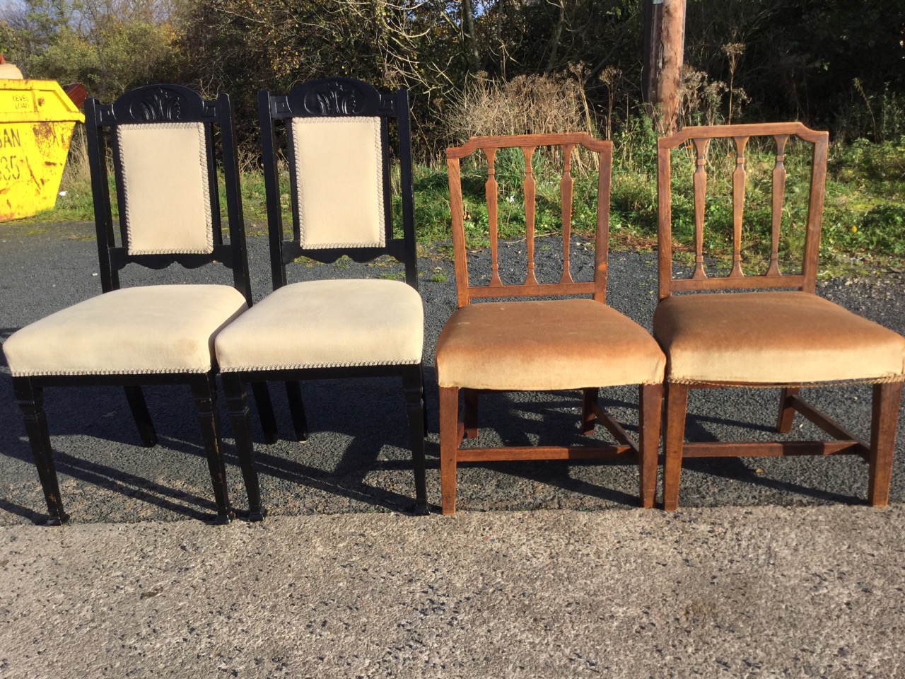 A pair of antique elm dining chairs with lathe backs above stuffover upholstered seats, raised on