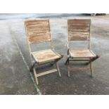 A pair of folding teak garden chairs with slatted backs & seats on rectangular legs. (2)