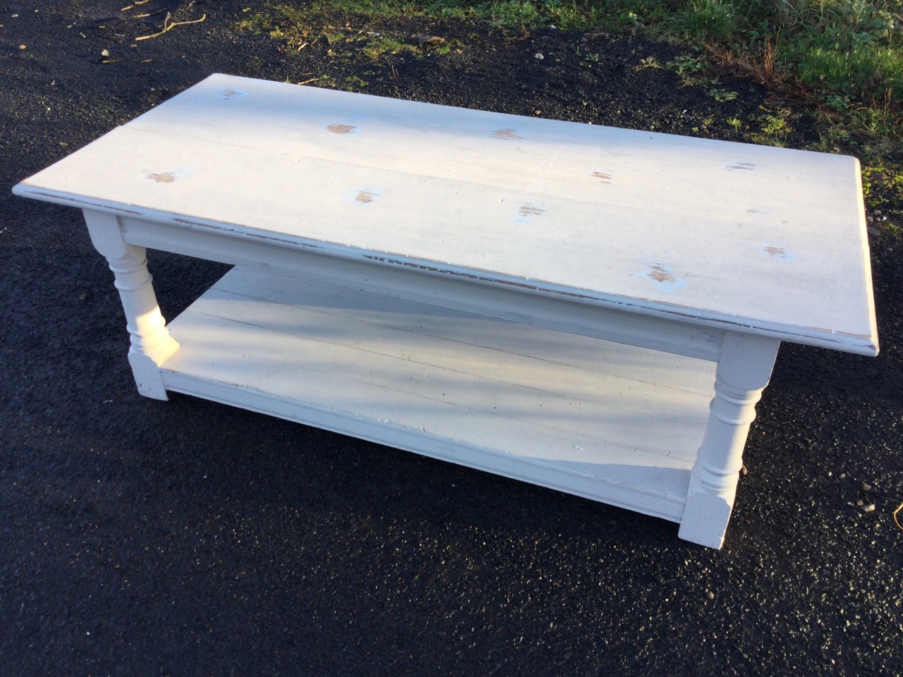 A painted rectangular oak coffee table, the moulded top on turned column legs united by platform