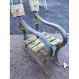 A pair of cast iron bench ends with substantial shaped rounded rails with sabre legs on pad feet. (