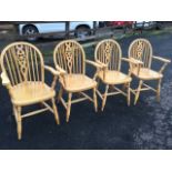 A set of four wheelback windsor chairs, the rounded backs on spindles framing pierced splats, the