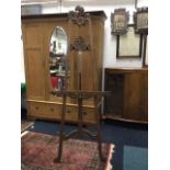 A large French walnut easel with pierced foliate scrolled carvings on moulded channelled
