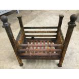 A cast iron dog grate, the rectangular basket with grill sides having turned front rails, the
