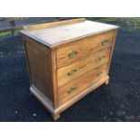 An oak chest with moulded top above three long drawers mounted with brass handles, above a moulded